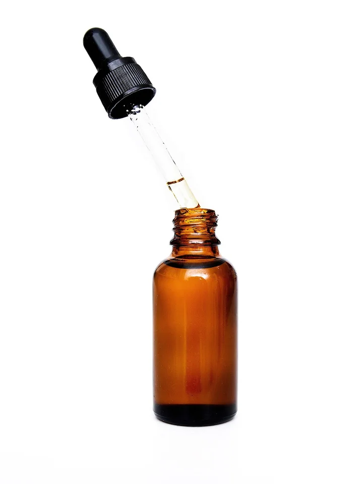 Amber glass dropper bottle with a dropper, used for skincare serums.