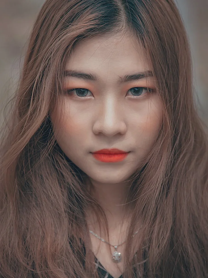 Close-up portrait of a woman with long brown hair and subtle makeup.