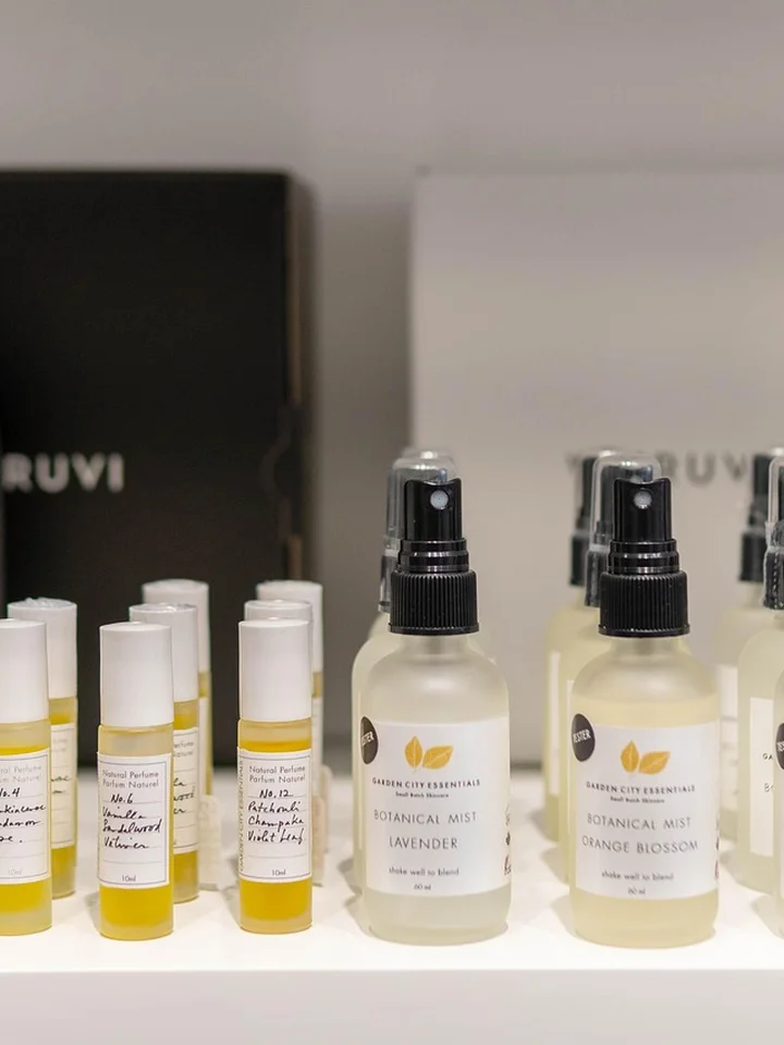 Assorted mandelic acid skincare products on a retail display, including small bottles and spray bottles with labels, arranged on a white shelf.