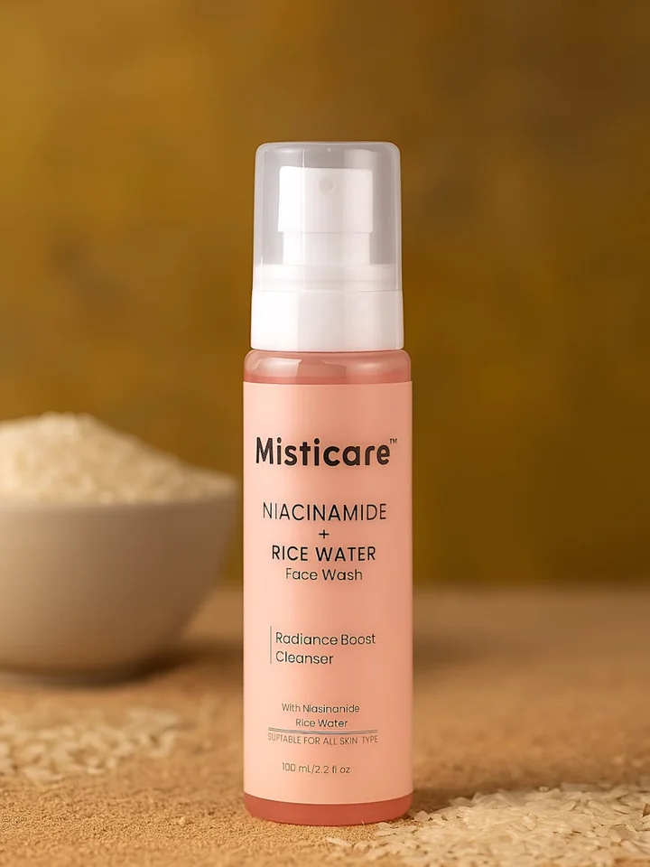 Pink bottle of Misticare Niacinamide Rice Water Face Wash with a pump dispenser on a warm beige background