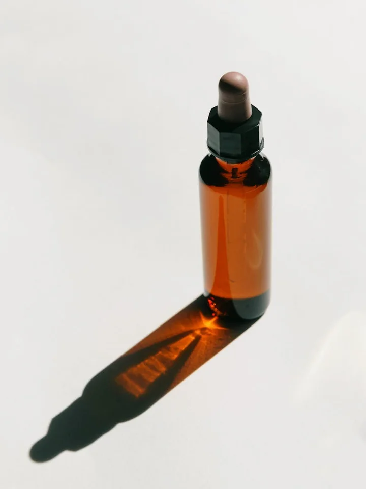 Close-up of a brown glass dropper bottle containing The Ordinary Alpha Arbutin 2% + HA serum on a white background
