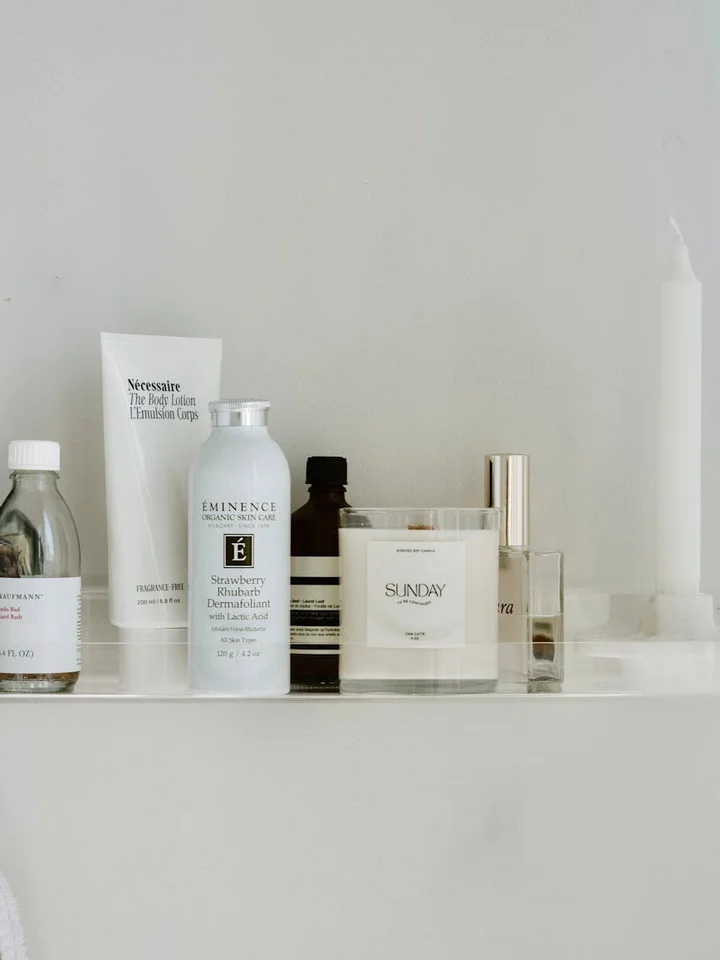 Assorted skincare products lined up on a clean white shelf in a minimalist bathroom, suggesting a turning point in a tretinoin treatment timeline.