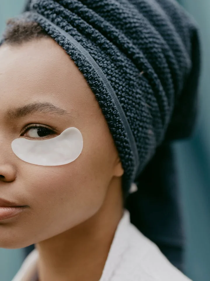 Close-up of a person wearing a white under-eye patch during a skincare routine
