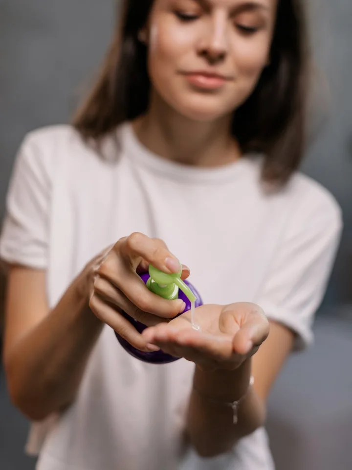 A person dispensing a small amount of topical gel onto their palm
