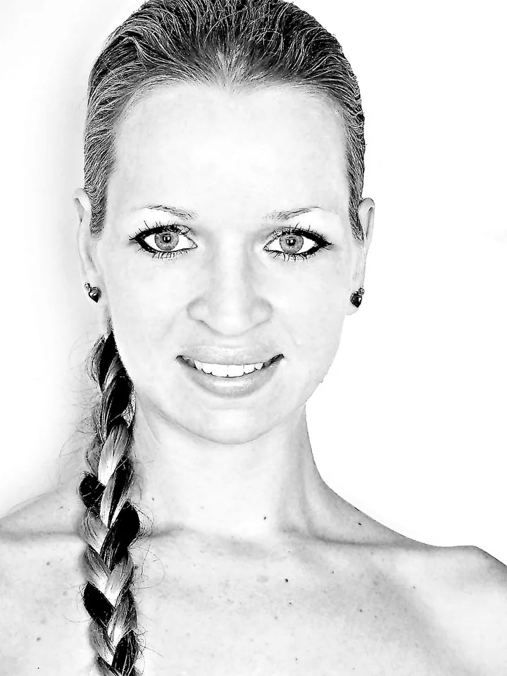 Black-and-white portrait of a smiling woman with a braided hairstyle.