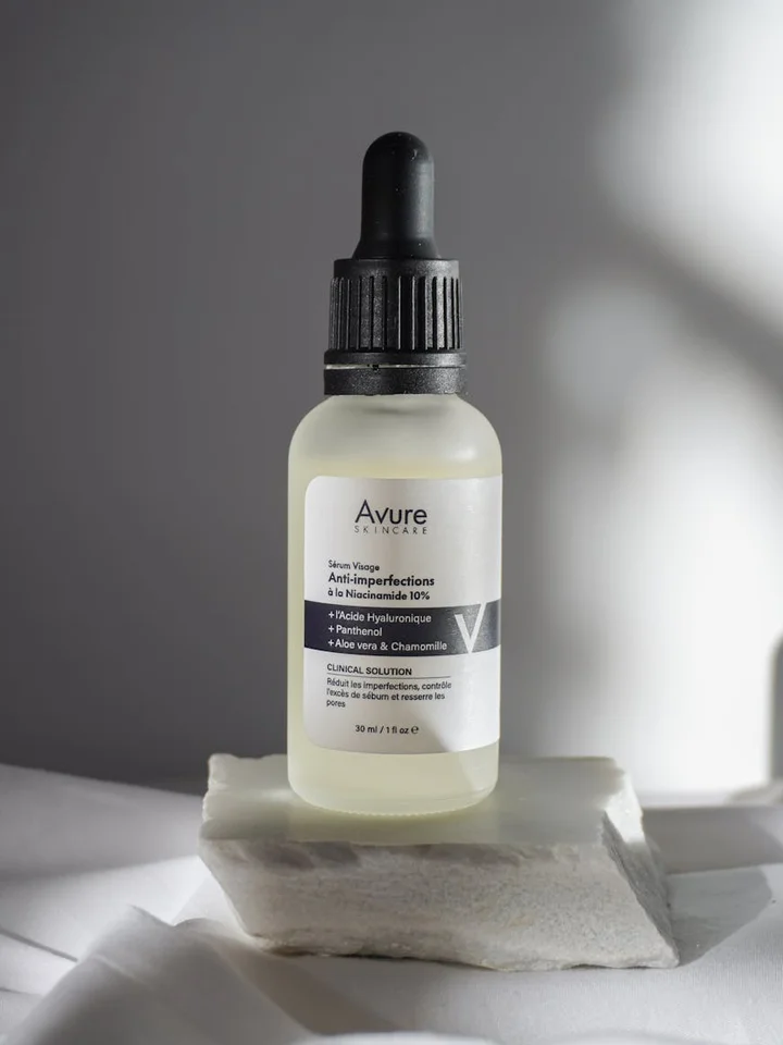 A dropper bottle of hyaluronic acid serum on a white surface with a soft gray background.