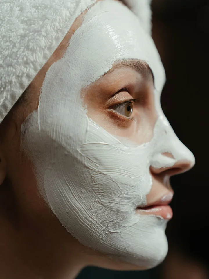 Close-up side profile of a person wearing a white facial sheet mask