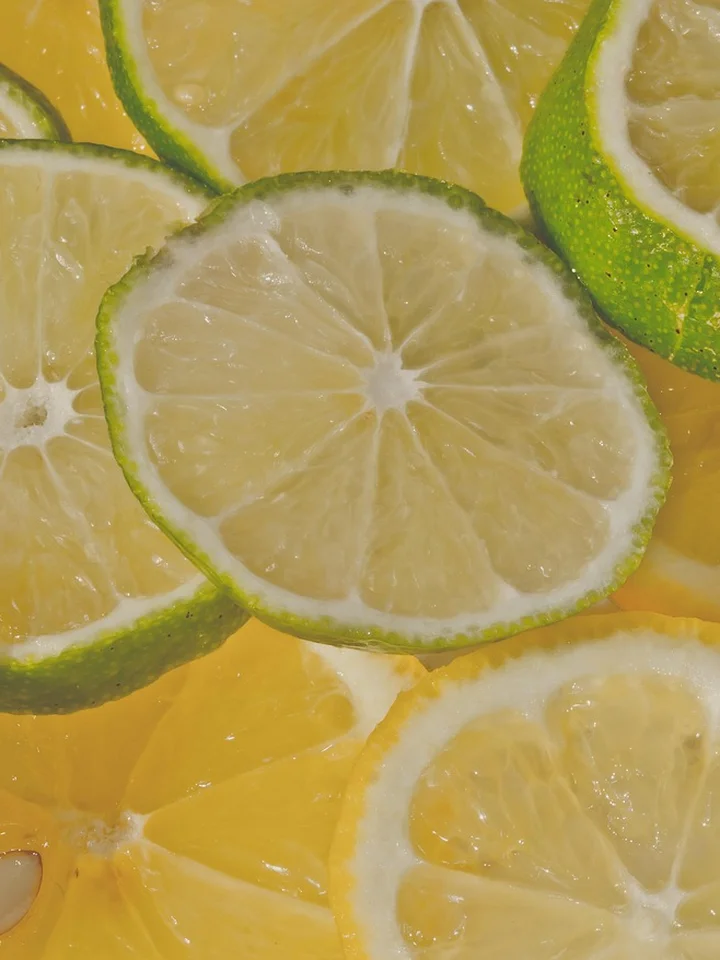 Close-up of overlapping lemon and lime slices with bright yellow and green hues.