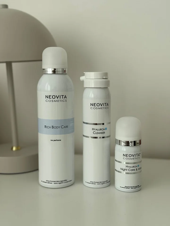 Three Neovita Cosmetics bottles on a white surface, including a Hyaluronic Cleanser and a Hyaluronic Night Cream