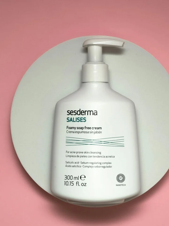 White pump bottle with Sesderma label on a pink circular background