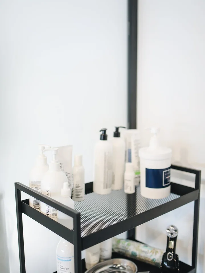 A tidy display of skincare products on a black metal shelf against a light background.