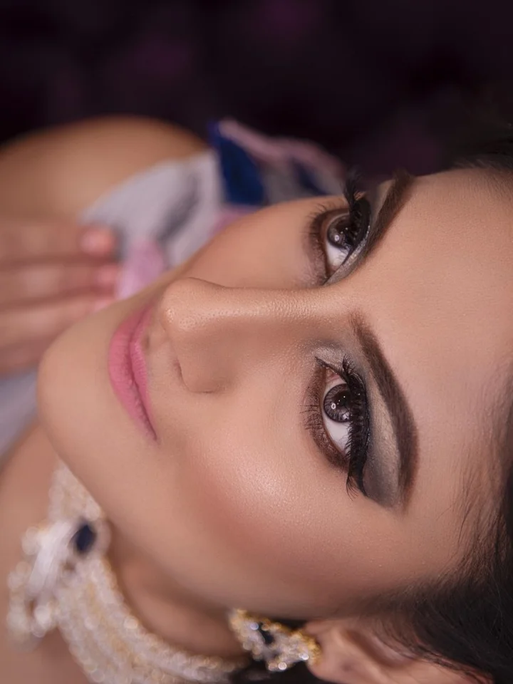 Close-up portrait of a woman with makeup, looking upward.
