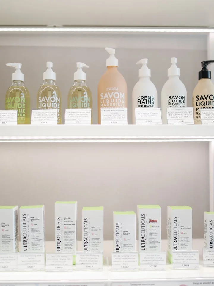 Shelf of skincare products on a retail display, with white bottles and boxed products lined up.