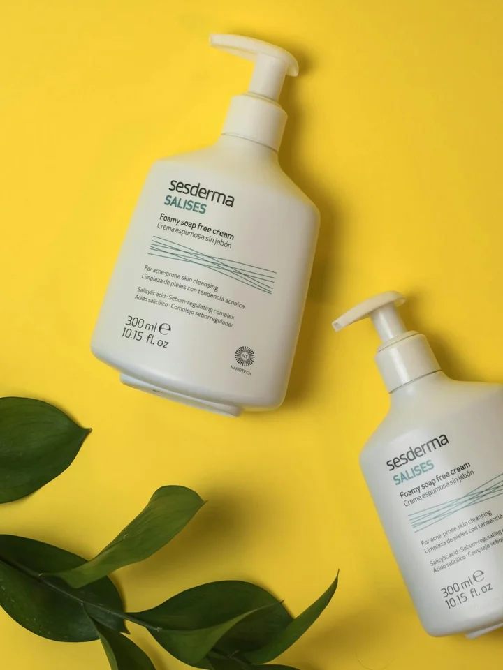Two white pump bottles labeled Sesderma on a bright yellow background with green leaves, representing gentle, non-comedogenic skincare options.